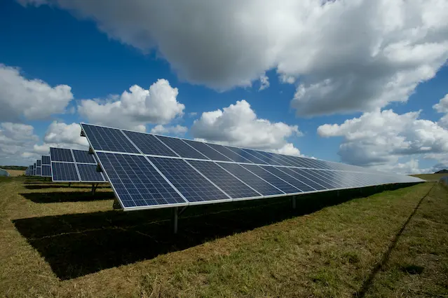 Aerial view of a large solar farm with rows of solar panels in a field