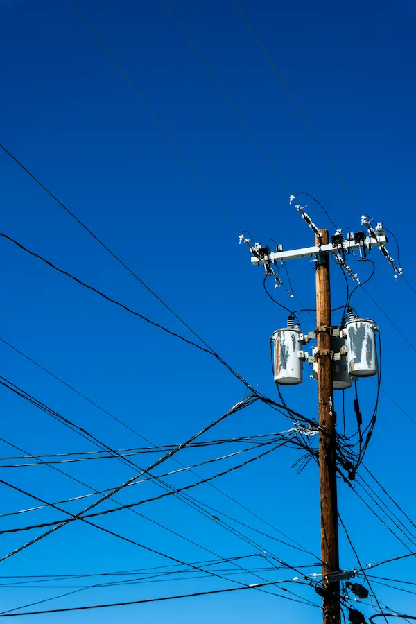 Lineman working on a utility pole with safety harness